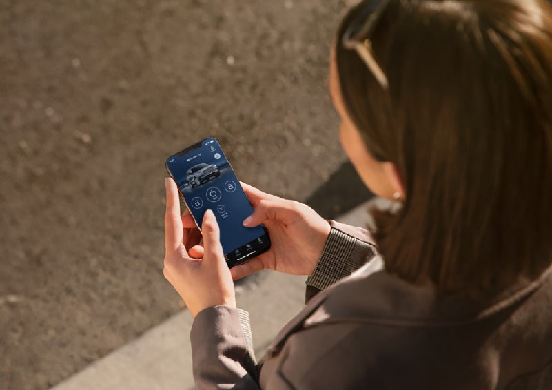 A person is shown interacting with a smartphone to connect to a Lincoln vehicle via the Lincoln Way® app. | Lincoln of New Bern in New Bern NC
