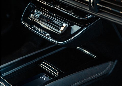 A smartphone rests on the available wireless charging pad in the front center console cubby | Lincoln of New Bern in New Bern NC