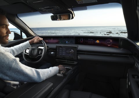 A driver of a parked 2026 Lincoln Nautilus® SUV takes a relaxing moment at a seaside overlook while inside his Nautilus. | Lincoln of New Bern in New Bern NC