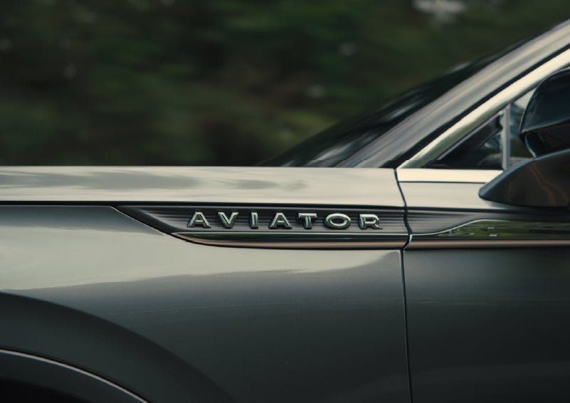 The driver’s side door and fender badging of a gray 2027 Lincoln Aviator® SUV are showcased. | Lincoln of New Bern in New Bern NC